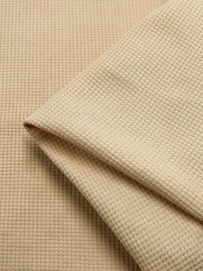 The Waffle Knit - Sun Kiss from Super Cheap Fabrics features a beige waffle texture with a grid-like pattern of small, raised squares. Its soft, three-dimensional appearance adds depth and texture to the fabric surface. Width: 170cm.