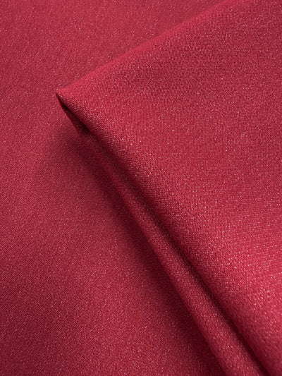 Close-up of folded Stretch Denim - Scooter Red (147cm) by Super Cheap Fabrics, highlighting its subtle texture, fine weave, and smooth ring-spun cotton surface.