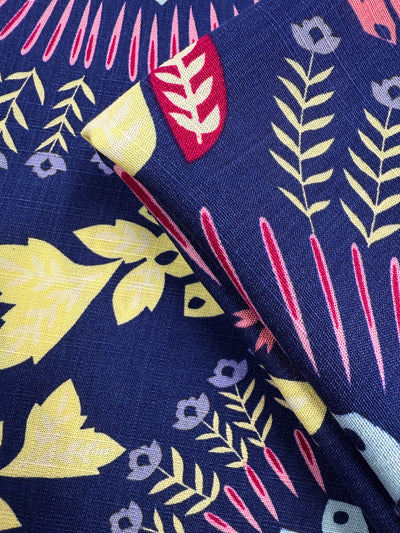 Close-up of Super Cheap Fabrics’ Bamboo Rayon - Midnight Carnival (150cm): two lightweight pieces with a navy base and vibrant yellow, pink, red, and light blue floral patterns—perfect for easy sewing projects.