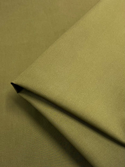 A close-up of Super Cheap Fabrics' Plain Cotton - Olive (147cm), showcasing its soft texture, matte finish, and lightweight quality.