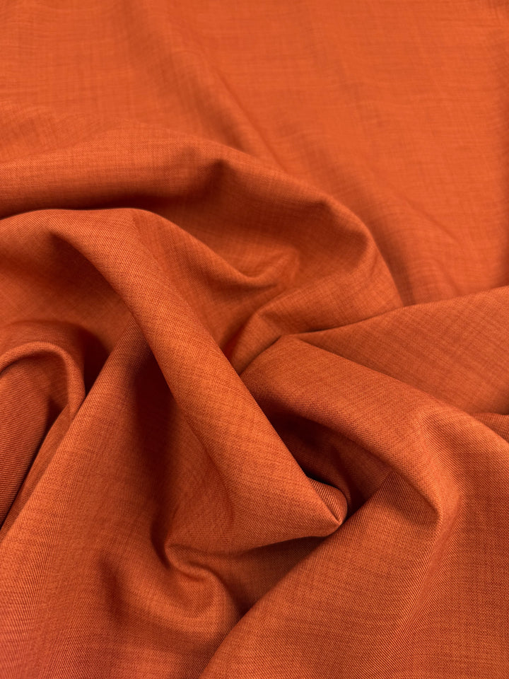 Super Cheap Fabrics' Twill Suiting - Rust - 150cm features orange polyester with a subtle diagonal weave, softly draping and gathering to create natural folds and shadows.