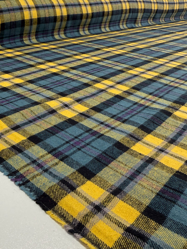 A close-up of Super Cheap Fabrics' Flannel Plaid - Highland Dusk (145cm), showcasing a tartan pattern with yellow, navy blue, and green stripes—perfect as a medium weight fabric for shirts.