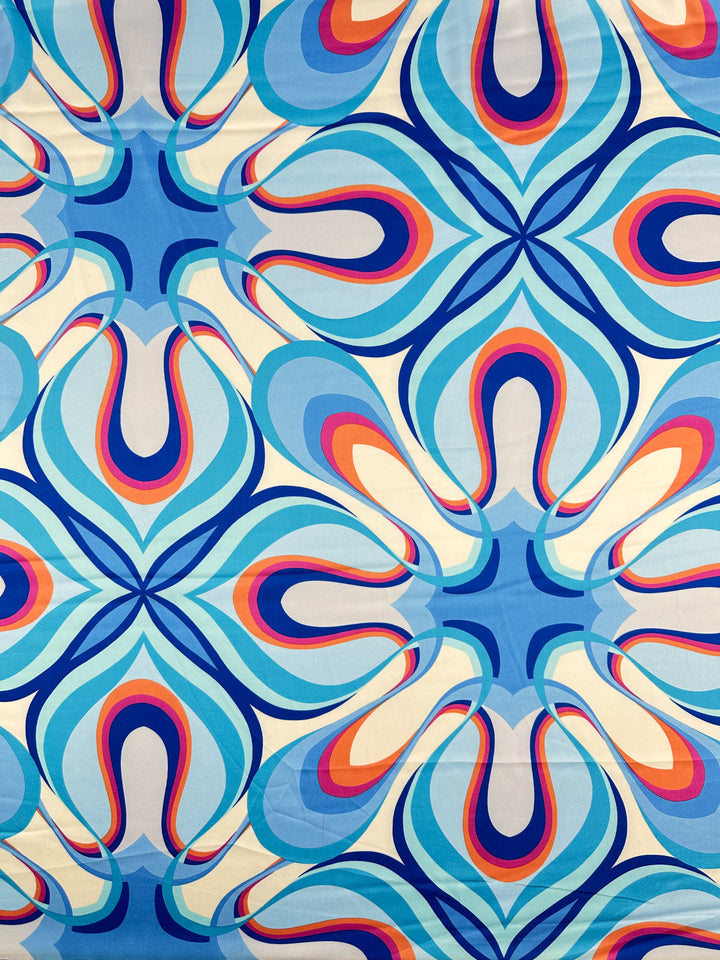 The Silky Satin - Burst - 150cm from Super Cheap Fabrics features a bold, colorful retro pattern with abstract wavy shapes and vivid hues, creating a symmetrical 1970s-inspired look—ideal for elegant crafts or printed satins.