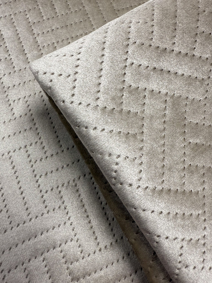 Close-up of Super Cheap Fabrics’ Embossed Velvet - Oatmeal (150cm), an extra heavyweight fabric with a soft texture and geometric zigzag pattern from small, even perforations—perfect for upholstering sofas or armchairs.