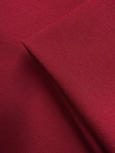 Close-up of two layers of Super Cheap Fabrics' Milano Ponte - Cabernet (160cm), highlighting the fabric's smooth texture, fine weave, and subtle stretch in a rich dark red shade.