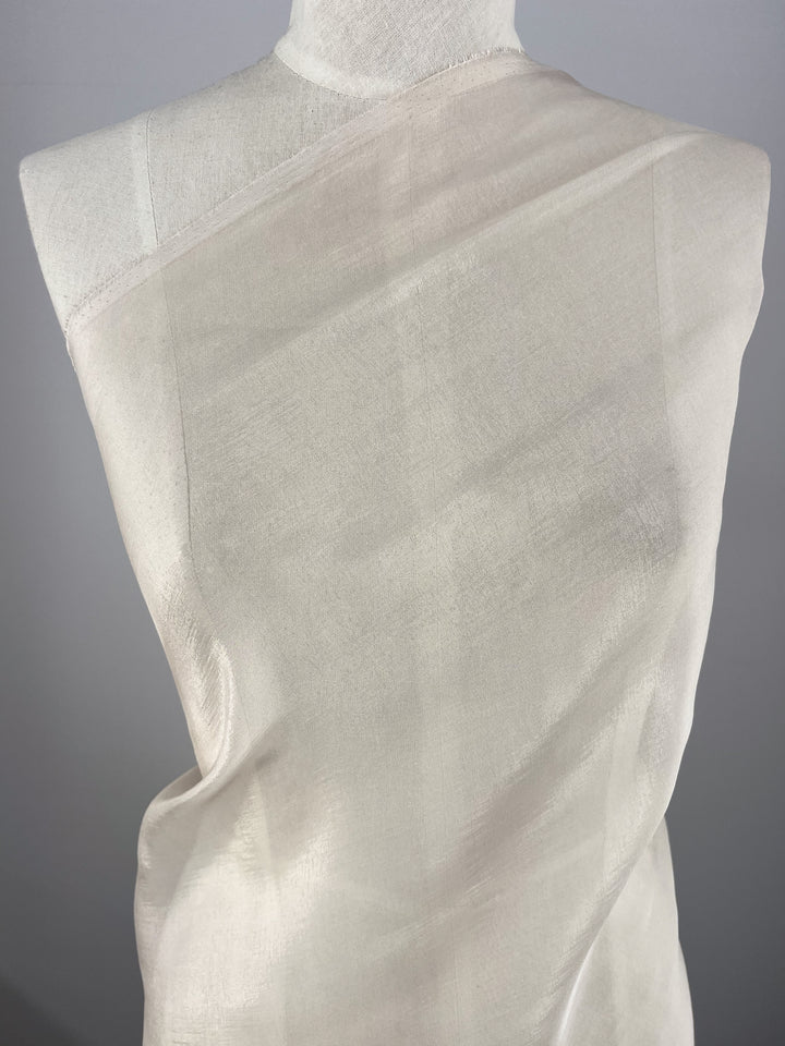Silk Mousseline - Mushroom - 140cm by Super Cheap Fabrics is a sheer, extra lightweight silk fabric that drapes softly over the shoulder and torso of a dress form, creating delicate folds and a translucent look.