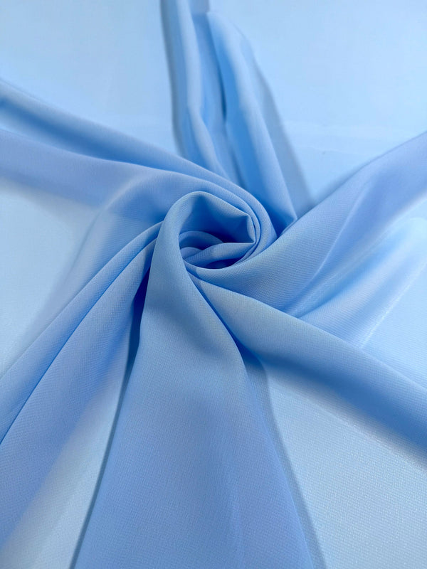 Hi-Multi Chiffon - Blue Grotto by Super Cheap Fabrics features light blue polyester in a spiral pattern, with soft, sheer folds radiating outward on a smooth surface. Width: 150cm.