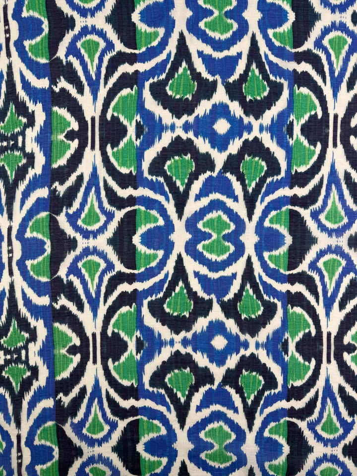 Textured Designer Cotton - Tribal Sea by Super Cheap Fabrics features a bold blue, green, black, and white ikat-inspired geometric pattern with jagged edges on lightweight 145cm cotton fabric.