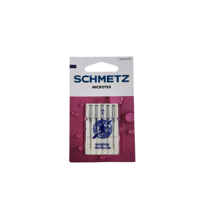A package of Super Cheap Fabrics Machine Needles Microtex is shown against a white background, featuring purple and pink designs on the lower part of the packaging.