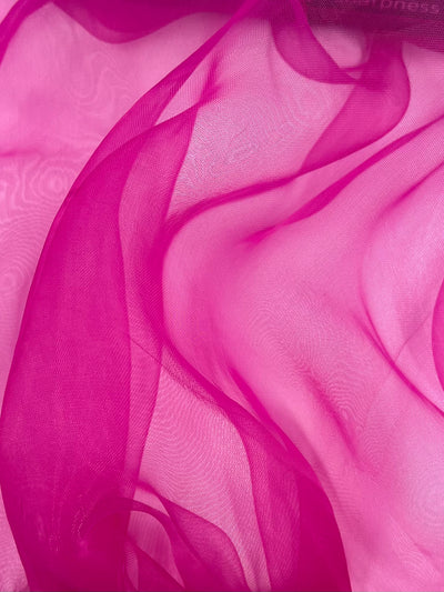 Super Cheap Fabrics’ Organza - Very Berry - 150cm features sheer, flowing nylon in pink and purple shades, draped in soft folds for a delicate, airy texture.