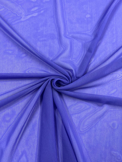 A close-up of Super Cheap Fabrics' Plain Mesh in Iris (155cm): semi-sheer, lightweight purple polyester, gathered at the center to form soft folds and a swirling pattern.